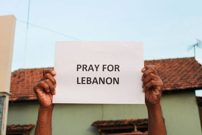 Text on human hand holding paper