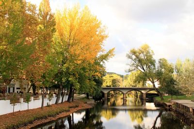 Arch bridge over lake against sky during autumn