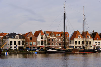 Sailing ship moored in haarlem on the spaarne in front of traditional dutch houses on hooimarkt.