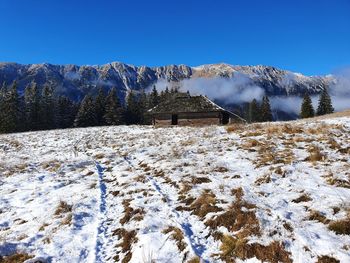 Scenic view of snow covered mountains against blue sky