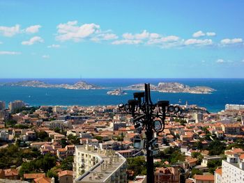 High angle view of townscape by sea against sky