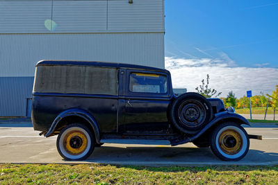 Vintage car on road against blue sky