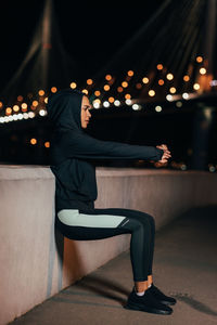 Side view of woman sitting outdoors