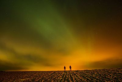 Silhouette of landscape against sky at night