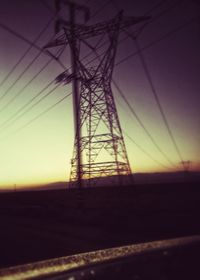 Electricity pylon against sky at sunset