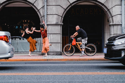 People riding bicycle on road in city