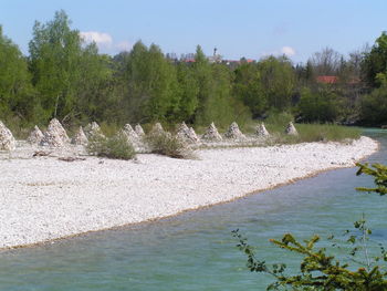 Scenic view of river by trees against sky