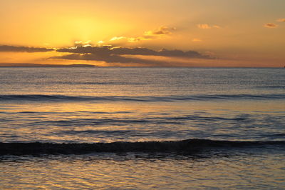 Scenic view of sea against dramatic sky during sunset