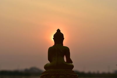 Statue of temple against sky during sunset