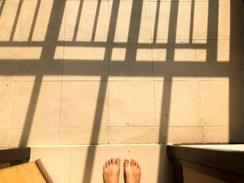 Low section of person standing on tiled floor