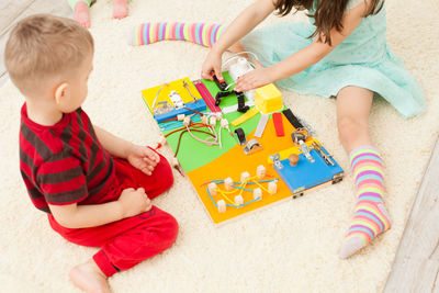 High angle view of boy playing with toy sitting on floor