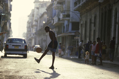 Rear view of man on street against buildings in city