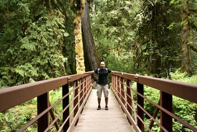 Rear view of man walking on footbridge