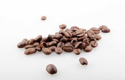 High angle view of coffee beans against white background