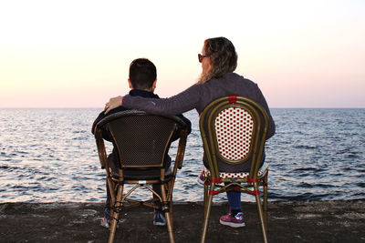 Rear view of woman sitting on beach