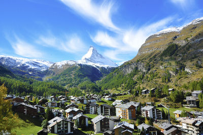 Buildings by mountains against sky during winter at zermatt