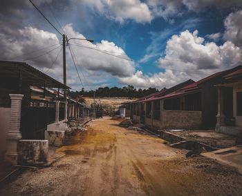 Road amidst buildings against sky