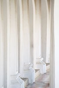 Close-up of white colonnade in empty corridor