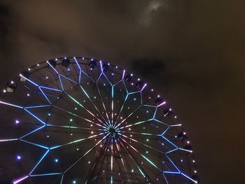 Low angle view of illuminated ferris wheel against sky at night