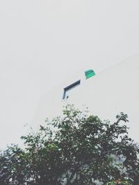 Low angle view of flag against building against clear sky