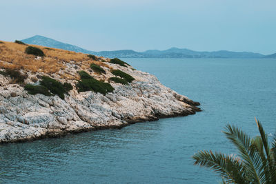 Scenic view of sea and mountains against clear sky