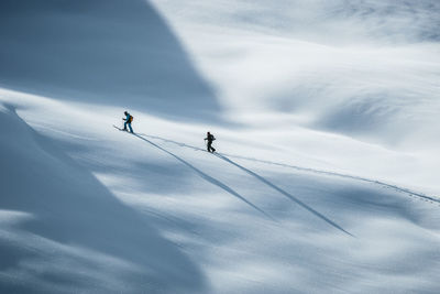Silhouette of two skiers ski touring in the backcountry of the alps in lienz, austria.