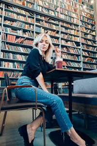 Portrait of young woman sitting on book