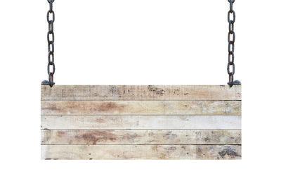 Close-up of empty swing against wall