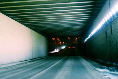 Empty road in illuminated tunnel