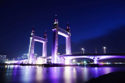 View of illuminated bridge over river at night