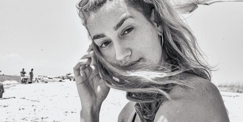 Portrait of woman at beach against sky