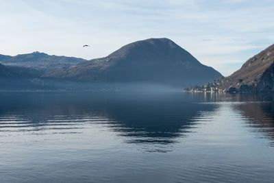 Scenic view of sea and mountains against sky