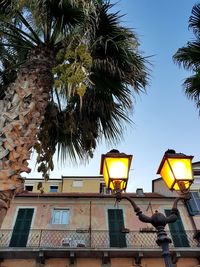 Low angle view of illuminated street light against sky