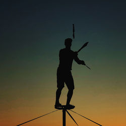 Low angle view of silhouette man standing against sky during sunset