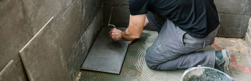 High angle view of mason worker applying tiles