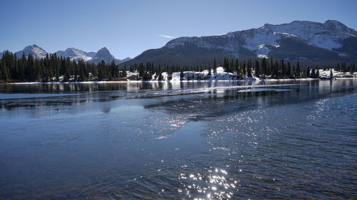Scenic view of lake against mountains during winter