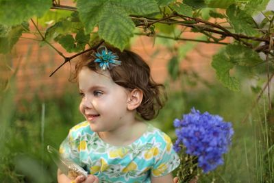 Portrait of young woman standing amidst plants