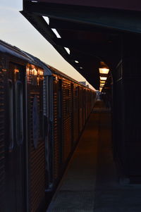 Illuminated railroad station by building