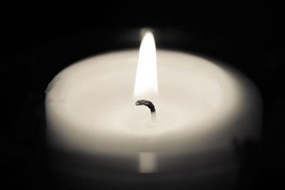 Close-up of illuminated light candle in darkroom