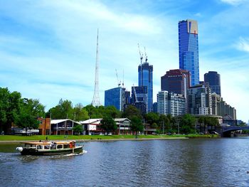 Scenic view of river by buildings against sky