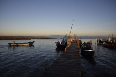 Boats on sea against sky during sunset