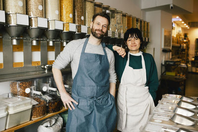 Portrait of male and female entrepreneurs standing in food store