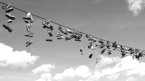 Low angle view of shoes hanging against sky
