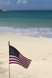 Low angle view of american flag on beach