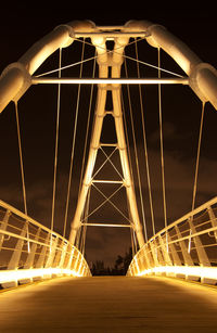 Low angle view of illuminated bridge against sky at night