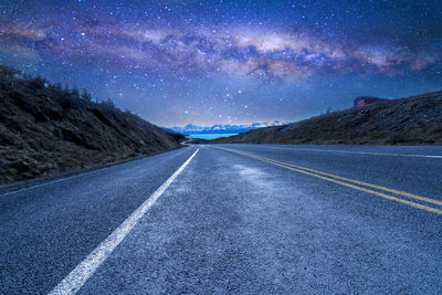 Road amidst landscape against sky at night