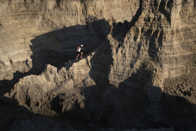 One man running up through a ridge on a sandy terrain