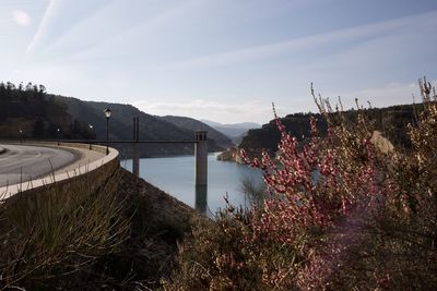 Scenic view of river by mountains against sky