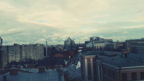 View of cityscape against cloudy sky