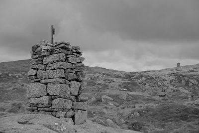 Stack of rocks on land against sky